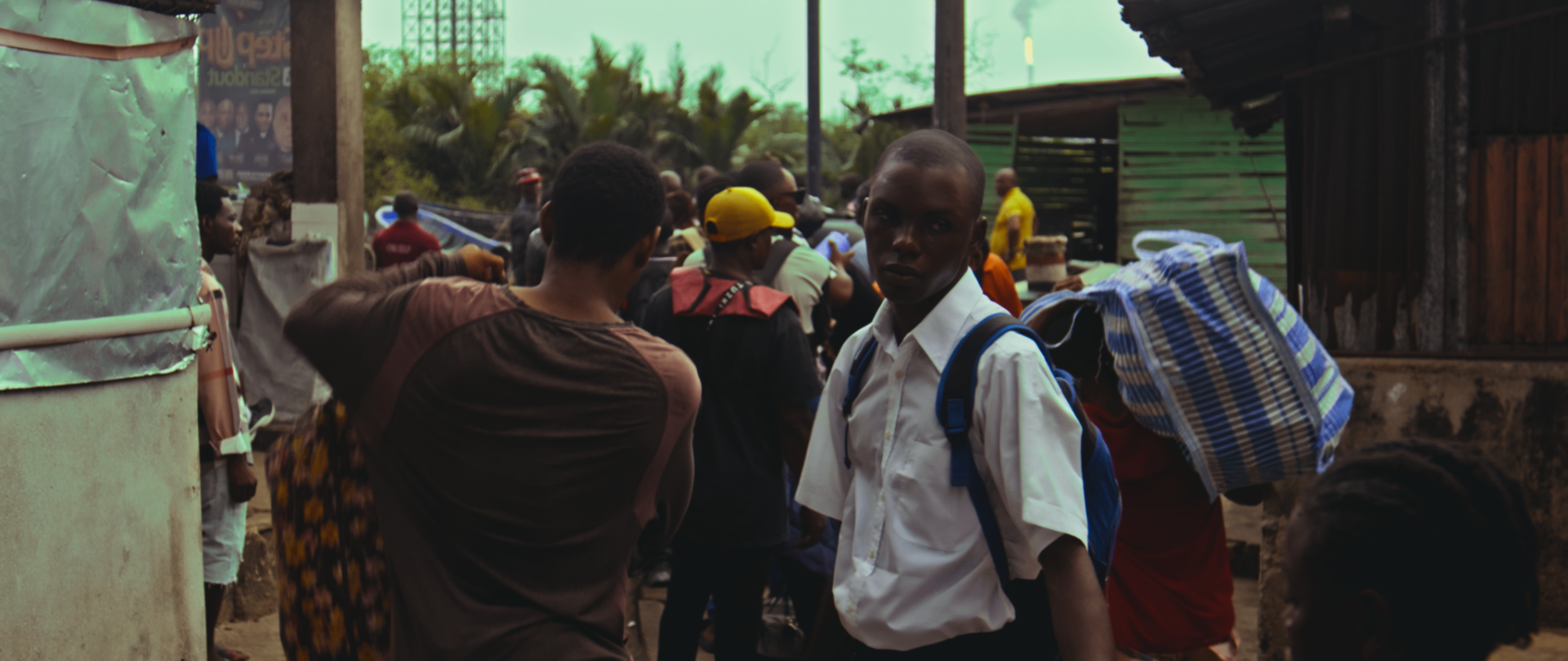 A schoolboy looks back through a busy street