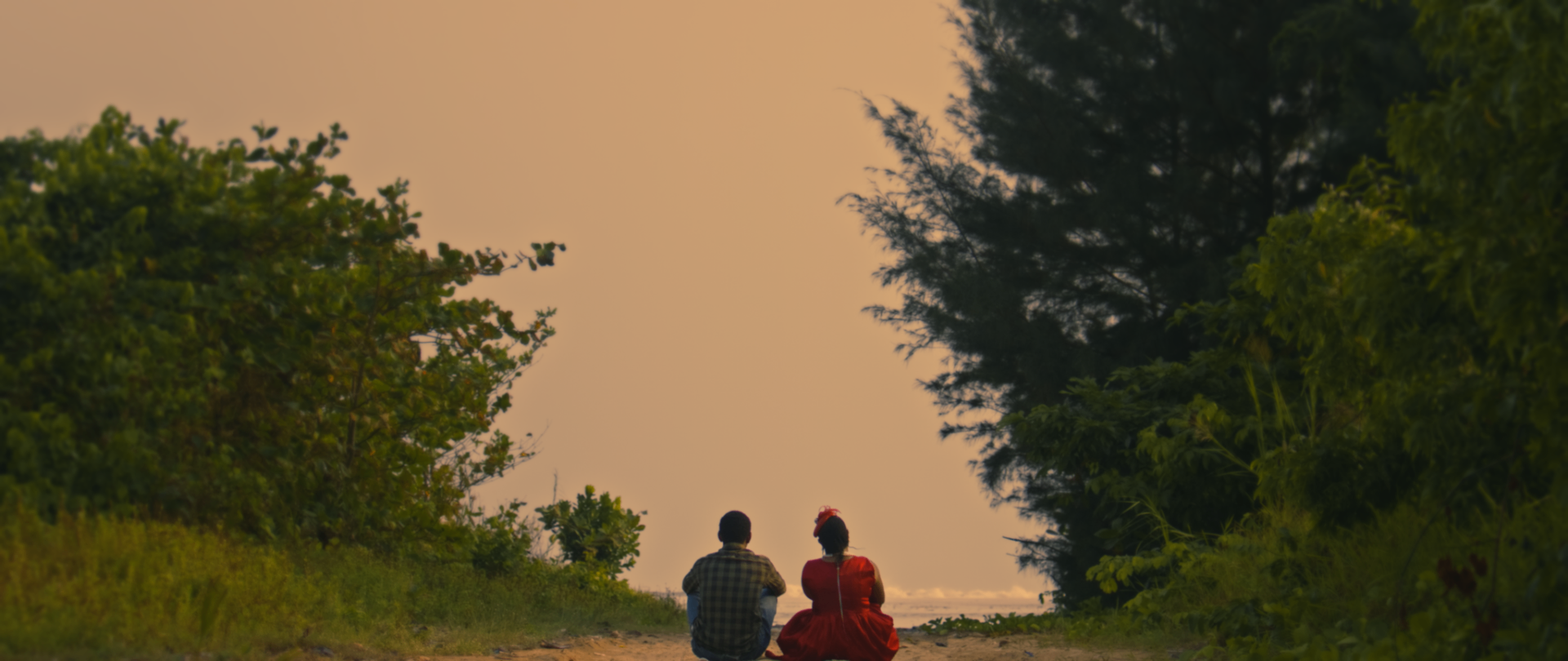 A couple sits together watching the sunset