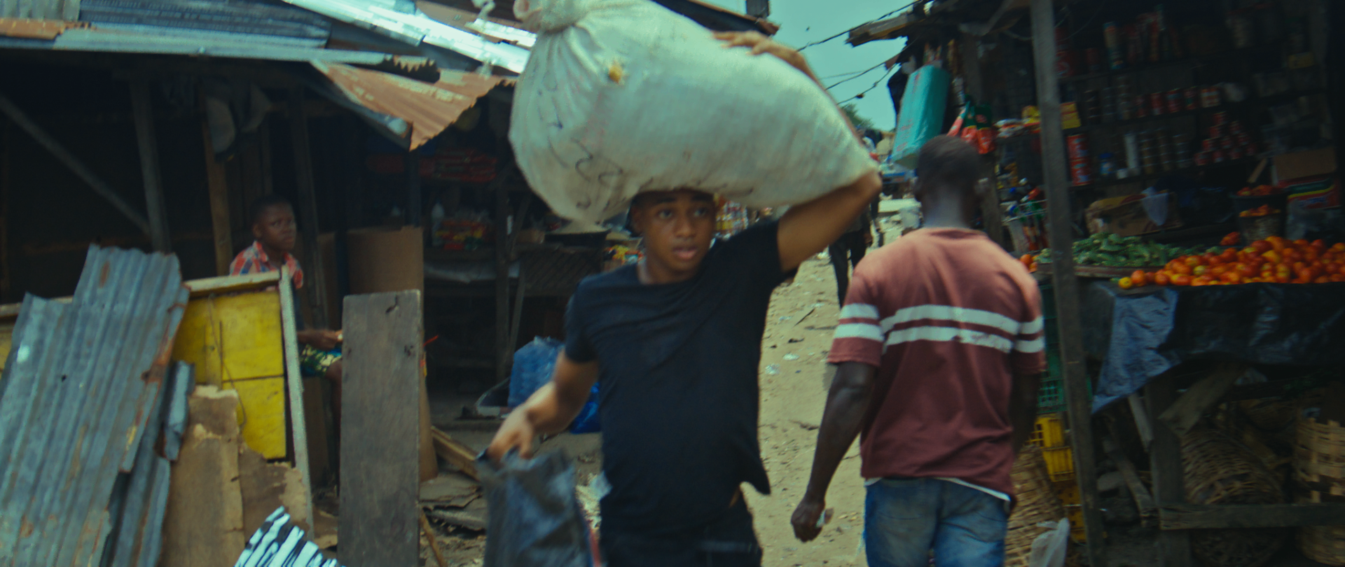 A boy carries a sack through the bustling market